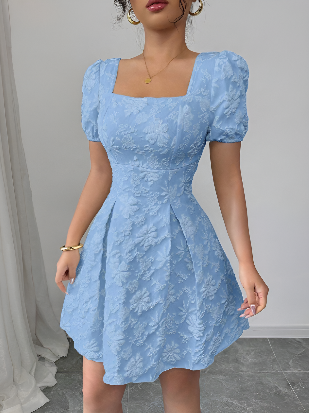 Sky Blue - Model wearing a textured floral jacquard mini dress with a square neckline, short puff sleeves, and a pleated A-line skirt