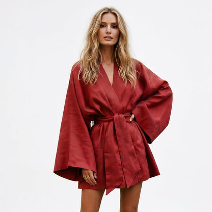 Red - Model wearing a relaxed linen-textured long-sleeve mini wrap dress with wide sleeves and a self-tie waist belt.