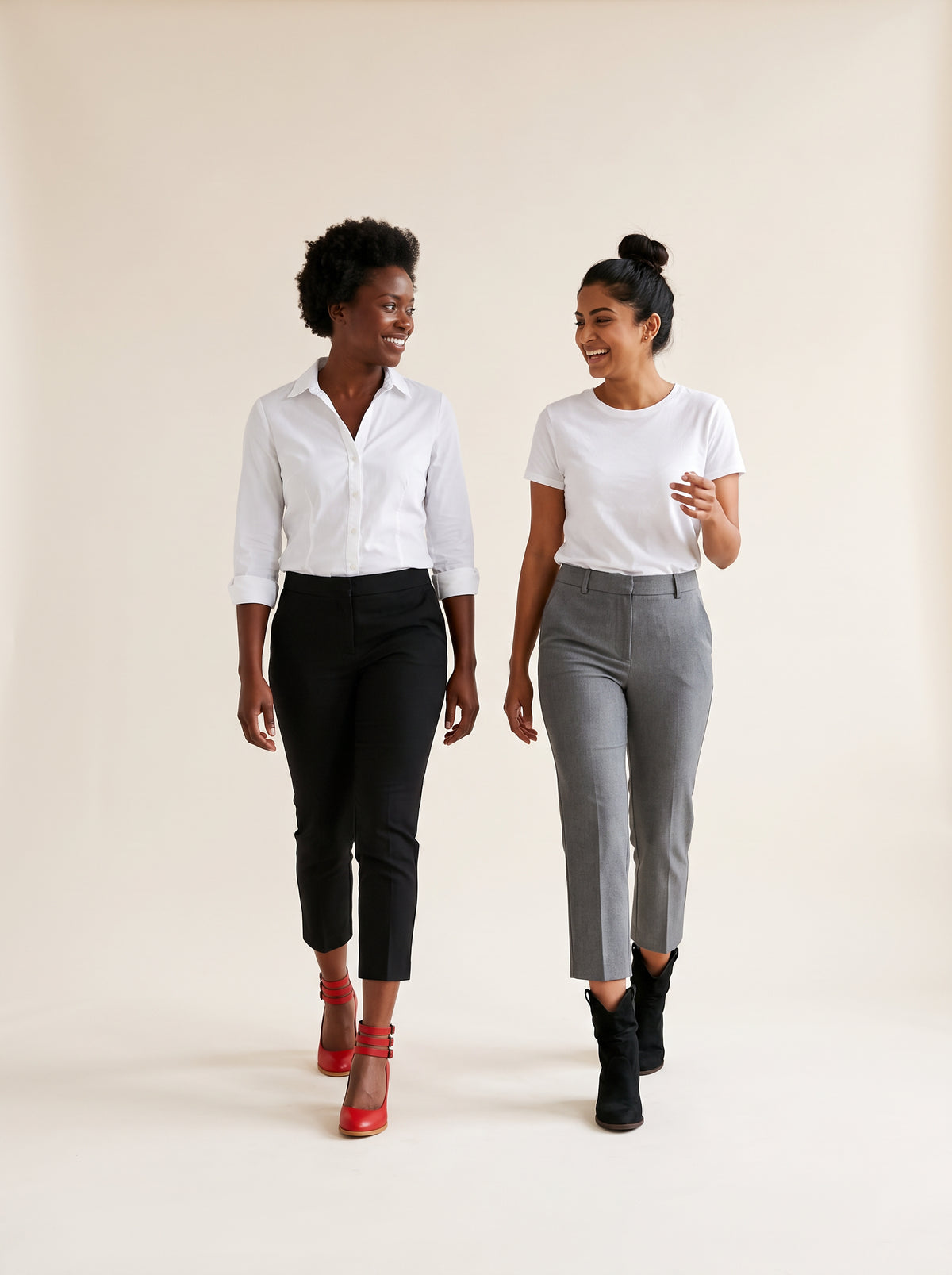 Two women walking together and laughing, one in wine red block heel pumps, one in black suede western ankle boots